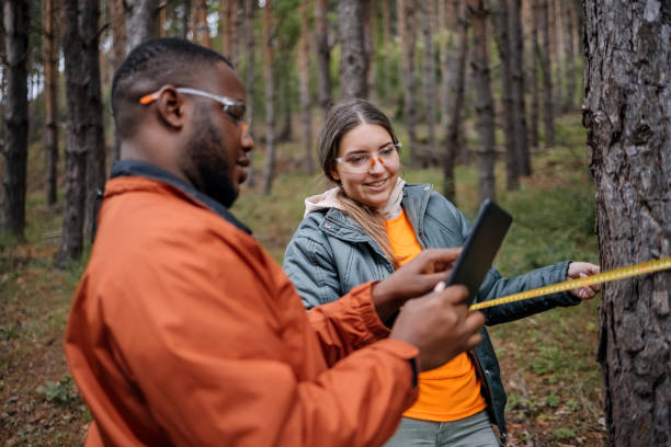 Young scientists doing research in nature measuring trees