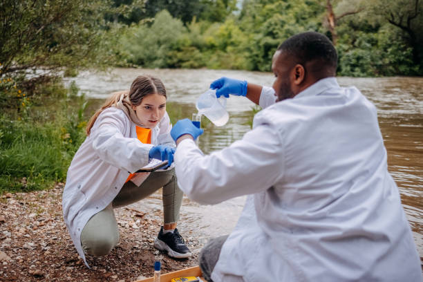 istock Young scientists doing research in nature taking sample of water from a river 2153542727