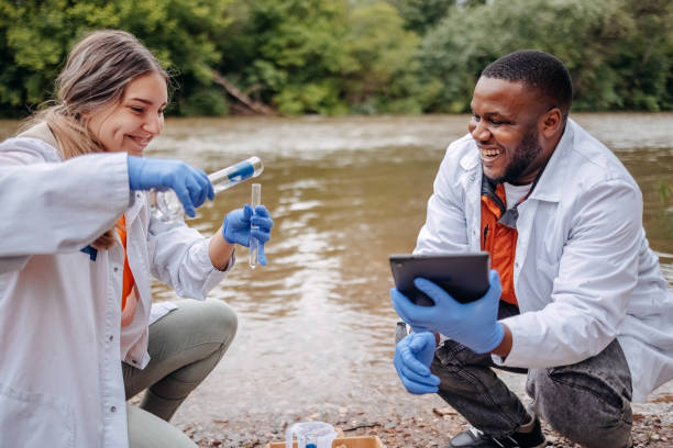 istock Young scientists doing research in nature taking sample of water from a river 2153542734