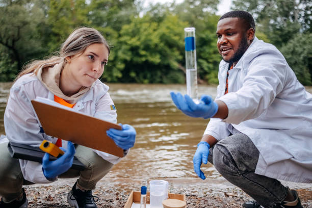 istock Young scientists doing research in nature taking sample of water from a river 2153542744