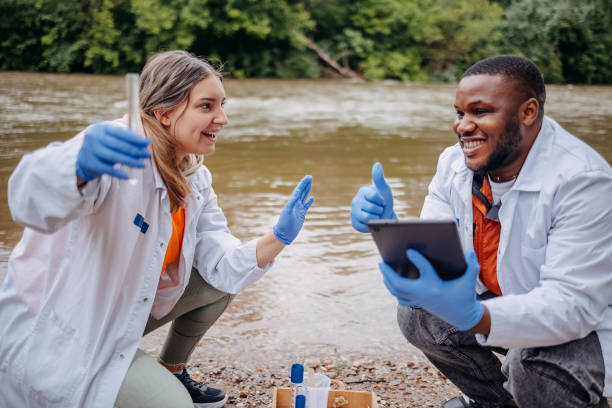 istock Young scientists doing research in nature taking sample of water from a river 2153542752