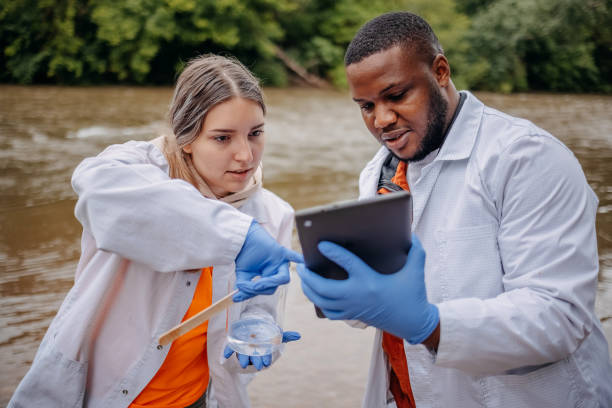 istock Young scientists doing research in nature taking sample of water from a river 2153542784