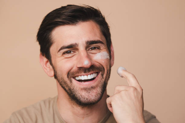 istock Smiling man applying facial cream 2153543999