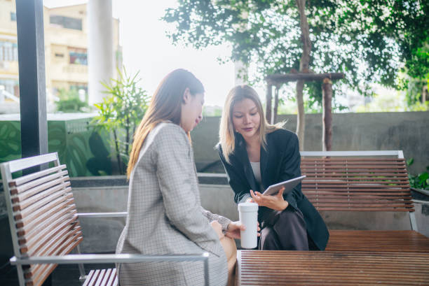 istock Happy colleagues meet in public space using tablets and laptops to present new projects together. 2153549600