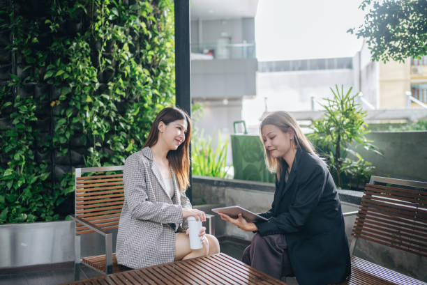 istock Happy colleagues meet in public space using tablets and laptops to present new projects together. 2153549690