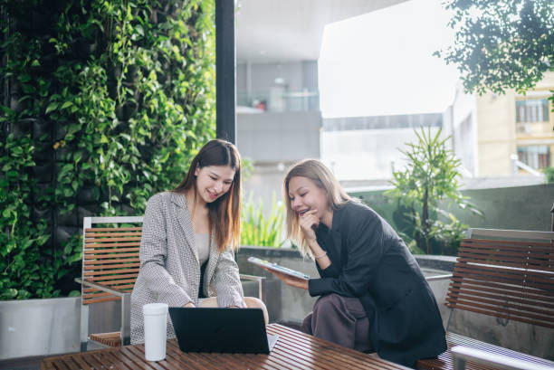 istock Happy colleagues meet in public space using tablets and laptops to present new projects together. 2153549821