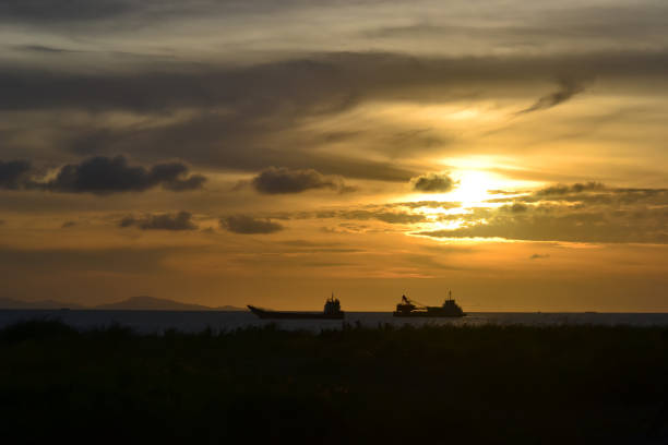 The scenery image of the vessel silhouette under the sunset sky
