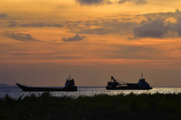 The scenery image of the vessel silhouette under the sunset sky