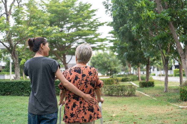 istock Caregiver Supporting Elderly Woman Outdoors. 2153552759