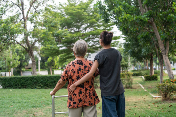istock Caregiver Supporting Elderly Woman Outdoors. 2153552763