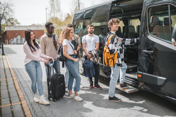 istock A cheerful young man with a yellow backpack on his back gets into the minibus 2153556381