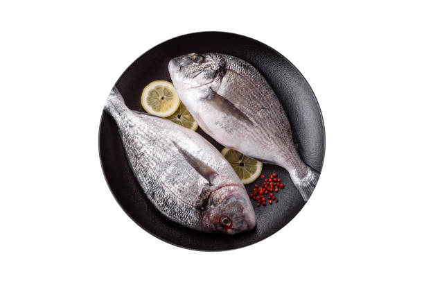 istock Whole raw dorado fish with lemon, salt, spices and herbs 2153562253