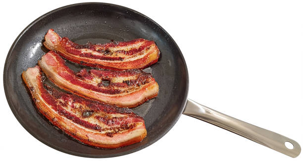 istock Freshly Fried Sizzling Crispy Crunchy Gourmet Pork Belly Bacon Rashers In Large Ceramic Coated Frying Pan Isolated On White Background High Resolution Stock Image 2153568190