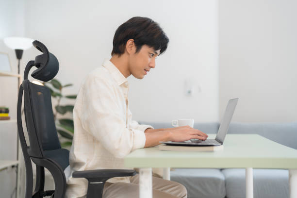 istock Young man working on laptop at home office 2153568882