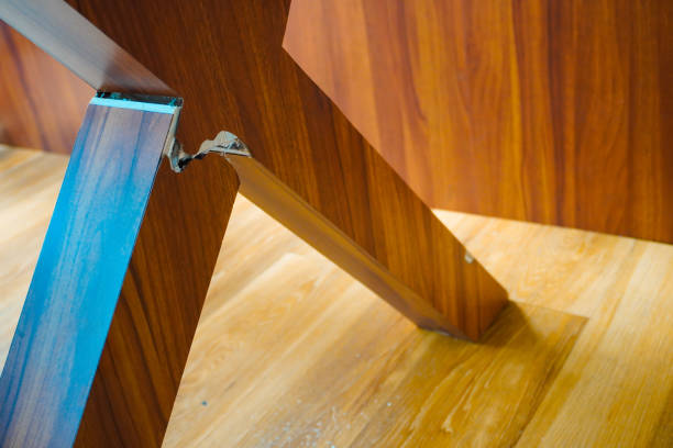 a broken wooden table leg, with a blurred background of someone sitting, creating an intriguing visual contrast