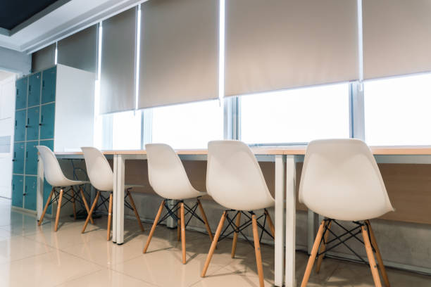 istock Office interior. Meticulously arranged white chairs on a chic and cozy desk 2153570991