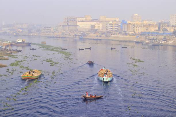 Sadarghat, Dhaka Bangladesh,  19 January 2024: Areal view of busy water channel - Buriganga  River. People are crossing it on small boat and ship's cargos and ferry's are transporting heavy stuffs