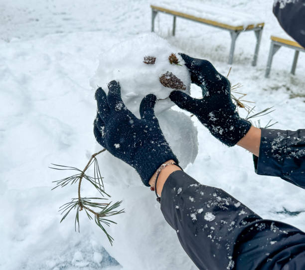 istock A man makes a snowman outdoors in winter 2153572719