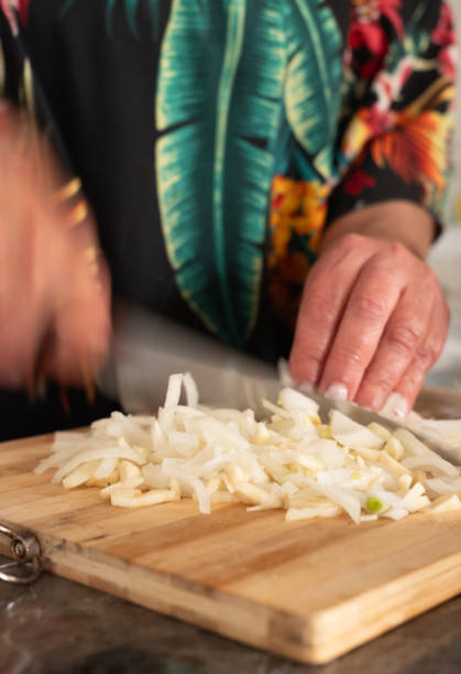 istock unrecognizable woman slicing garlic on cutting board.motion blur vertical image. 2153574614