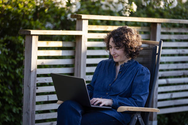 istock Pretty young lady is working from home at backyard. 2153581547