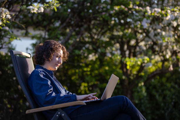 istock Pretty young lady is working from home at backyard. 2153581552