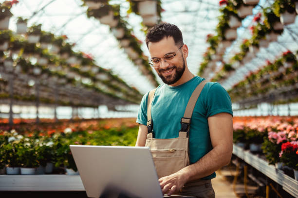 istock Male Botanist Using Laptop in a Plant Nursery 2153581616