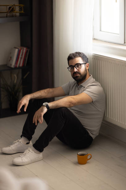 istock Man sitting alone at home looking sad and distraught 2153585259