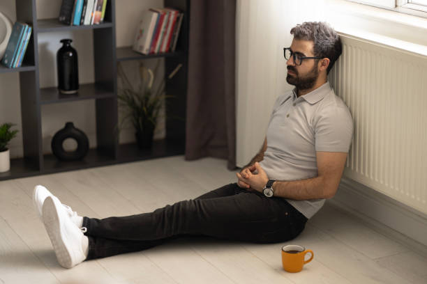 istock Man sitting alone at home looking sad and distraught 2153585404