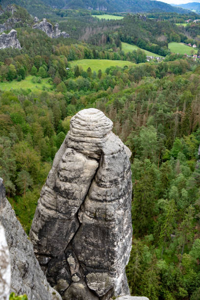istock A mountain with a large rock on top and a lush green forest below 2153587076
