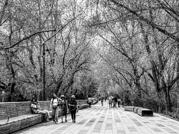 Calgary, Alberta - May 14, 2024: People walking along the pathways in the Eau Claire district on a spring day in Calgary