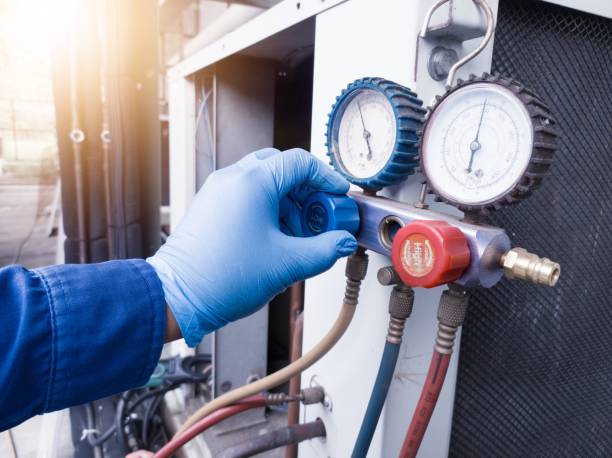 istock HVAC system service technician using measuring manifold gauge checking refrigerant and filling industrial air conditioner. 2153595278