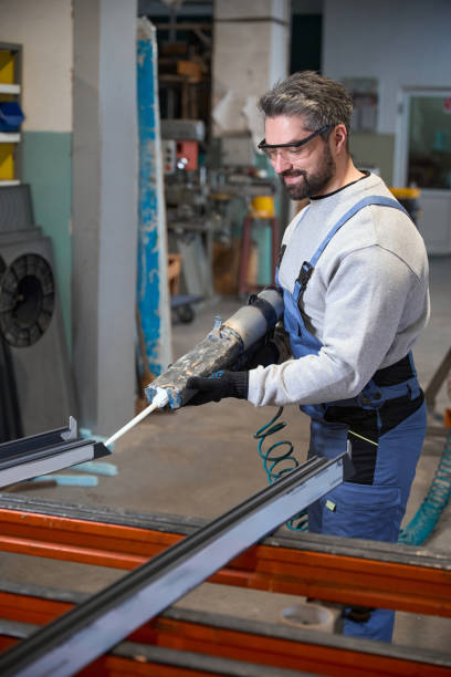istock Worker works with an aluminum profile in a production workshop 2153595566
