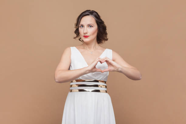 istock Woman confesses in love, makes heart gesture, shows her true feelings, has happy expression. 2153597629