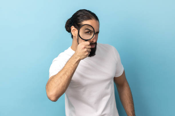 istock Man looking through magnifying glass, spying, finding out something, exploring crime scene. 2153598258