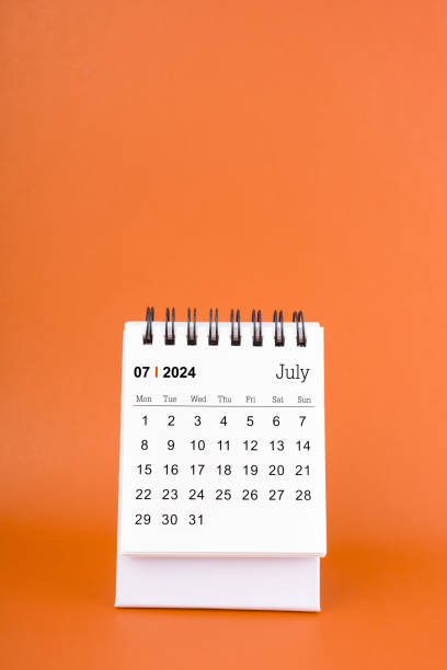 istock Vertical of July 2024 table calendar on orange background. 2153608499