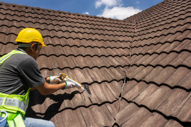 istock Worker man using silicone sealant adhesive  to fix crack of the old tile roof. 2153612092