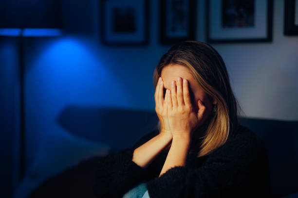 istock Sad Woman Covering her Face Crying Alone on the Sofa 2153614278