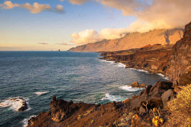 The flaming sunset light illuminates the rocky coast of El Hierro, in the Canary Islands, Spain