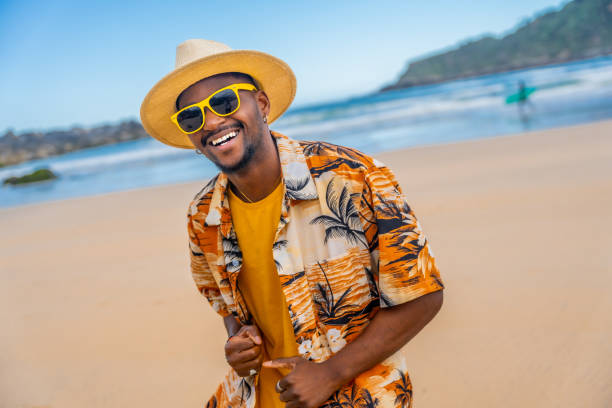 istock Afro american man in summer clothes dancing happily at beach 2153627722