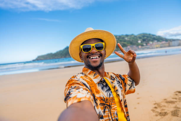 afroameričan si dělá selfie gestikuluje vítězství na pláži - selfie - stock snímky, obrázky a fotky