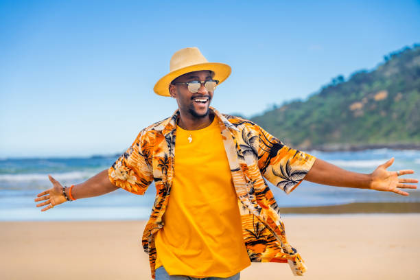 istock African man walking with arms opened at beach 2153627905