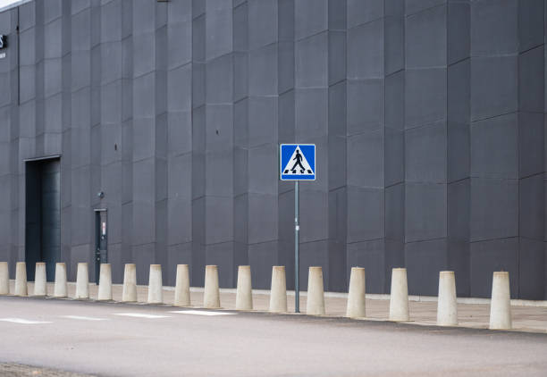 Sign marking a zebra crossing by a warehouse.