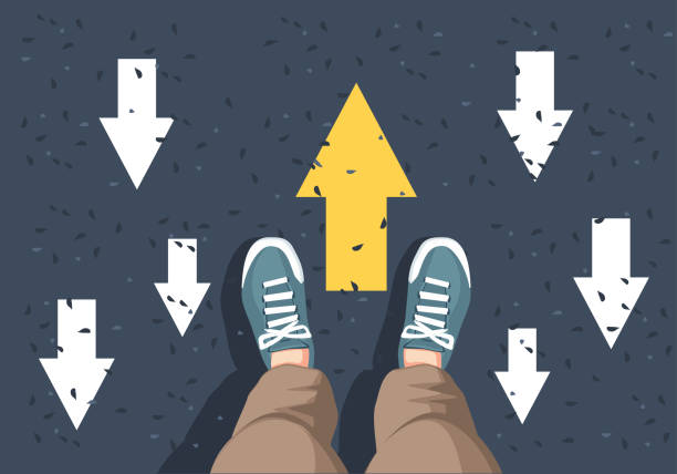 istock man sneakers on asphalt and opposing direction arrows on asphalt 2153628961