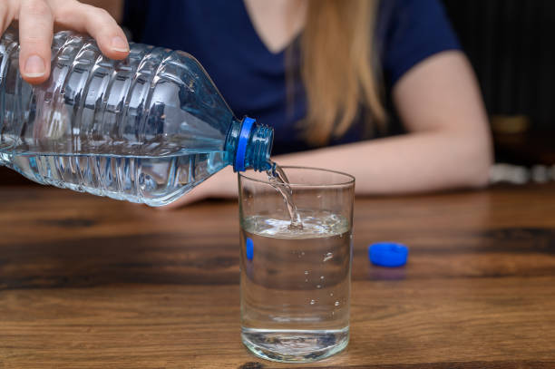 istock Bottled spring water in a glass, plastic bottle and body hydration 2153631219