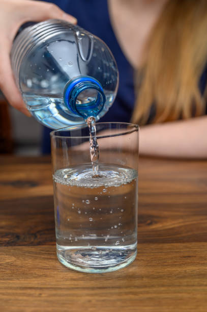 istock Drinking water, pour cold still water from a plastic bottle into a glass 2153631346