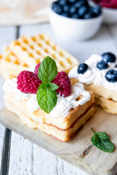 Belgian Waffles with cream and fruit. on a wooden background.