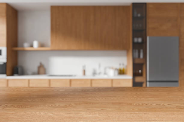 istock A blurred modern kitchen interior with a wooden tabletop in focus in the foreground, on a light background, concept of home design. 3D Rendering 2153632913