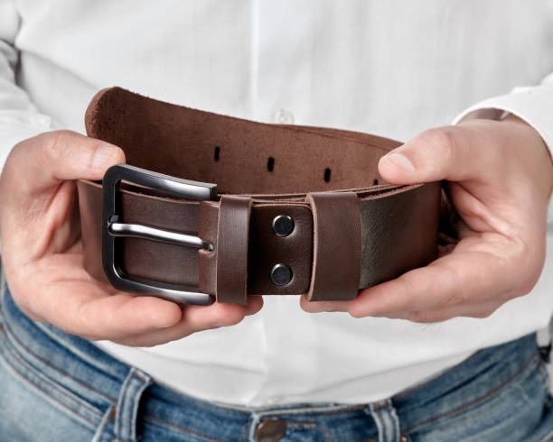 istock Handcrafted dark brown leather belt with DAD embossing in hands 2153634317
