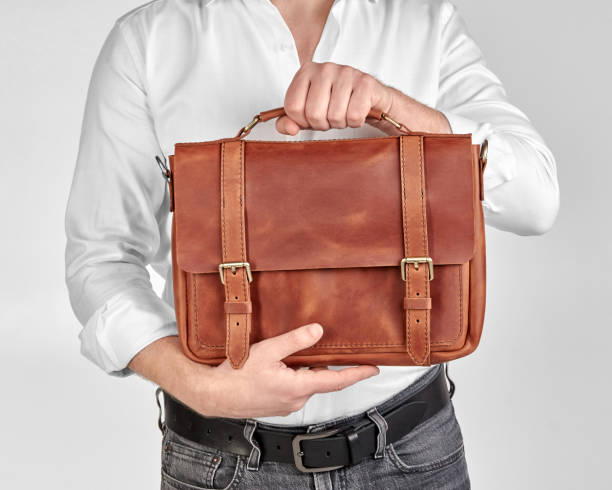 istock Custom brown leather briefcase with embossed initials in male hands 2153634407