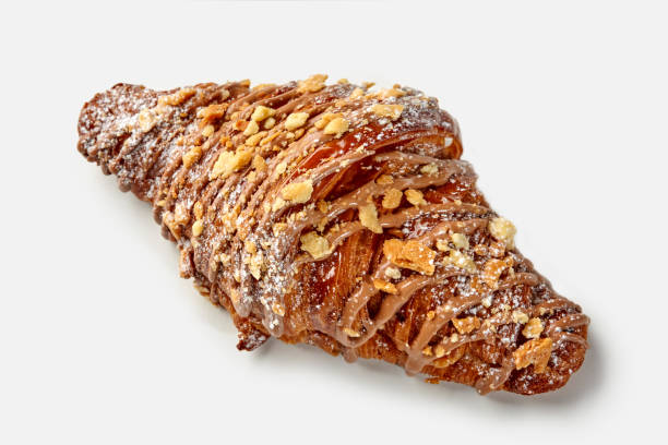 Golden croissant with chocolate icing and caramelized crumbles